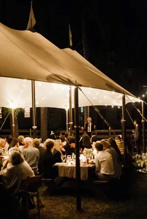 An evening reception under the lit tent